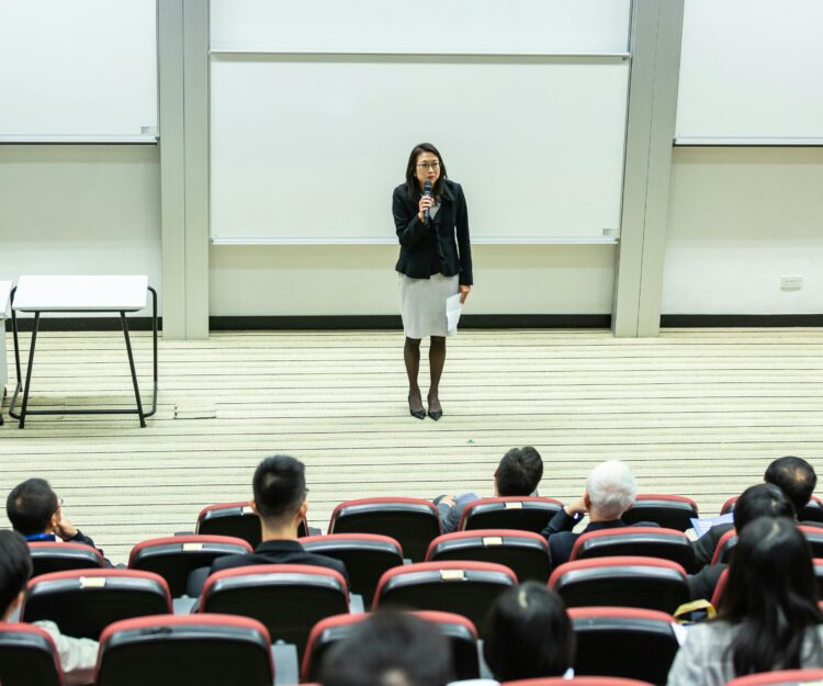 Woman holding microphone standing in front of crowd